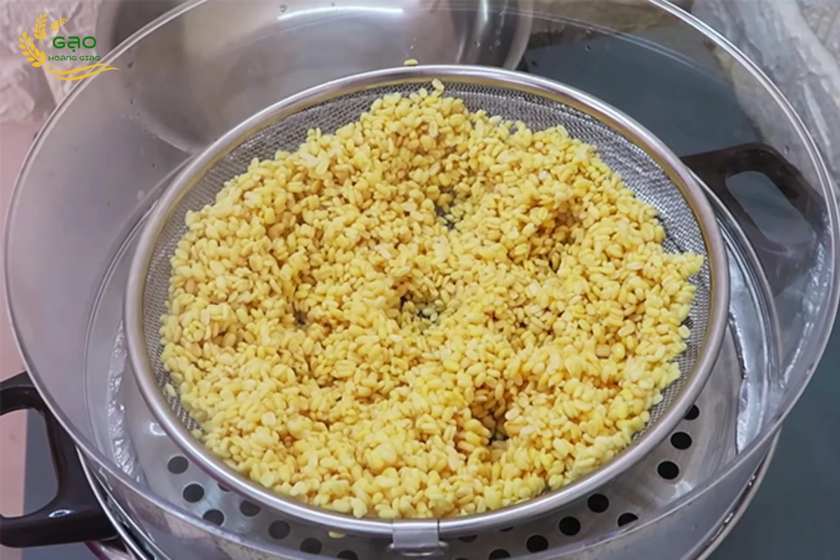 Dùng đũa chọc vài lỗ trên bề mặt nếp để xôi nhanh chín đều